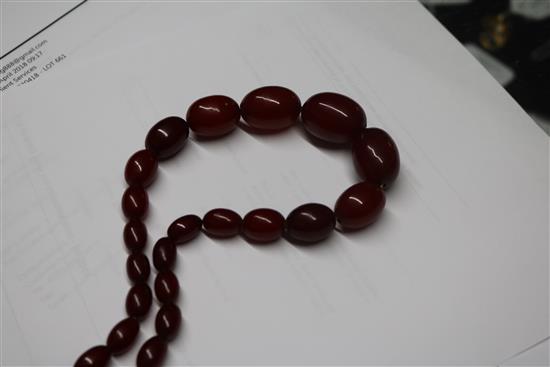 A single strand graduated simulated cherry amber oval bead necklace, gross weight 68 grams, 70cm.